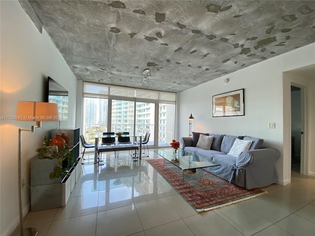 living room with floor to ceiling windows and light tile patterned floors