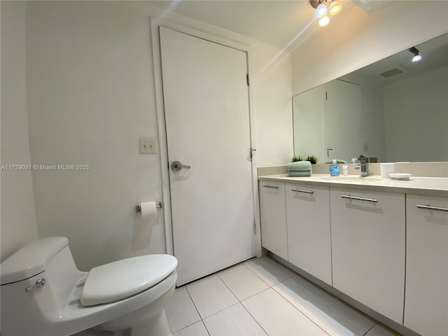 bathroom with toilet, tile patterned flooring, and vanity