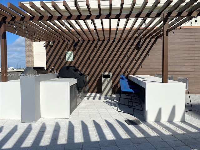 view of patio with a bar, area for grilling, and a pergola