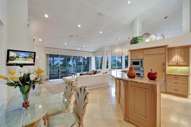 kitchen featuring appliances with stainless steel finishes, a center island, decorative backsplash, light stone counters, and light tile patterned floors