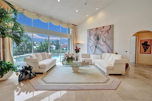 tiled living room with a textured ceiling and a towering ceiling