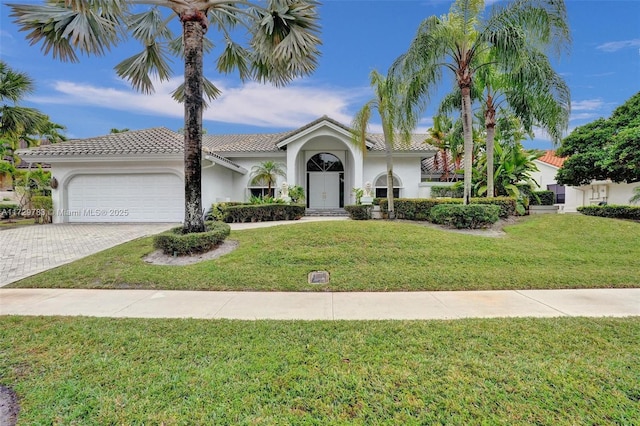 mediterranean / spanish home with a garage and a front yard