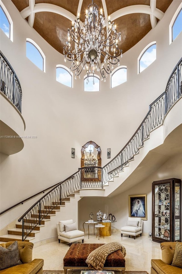 interior space with a healthy amount of sunlight, a towering ceiling, and a notable chandelier