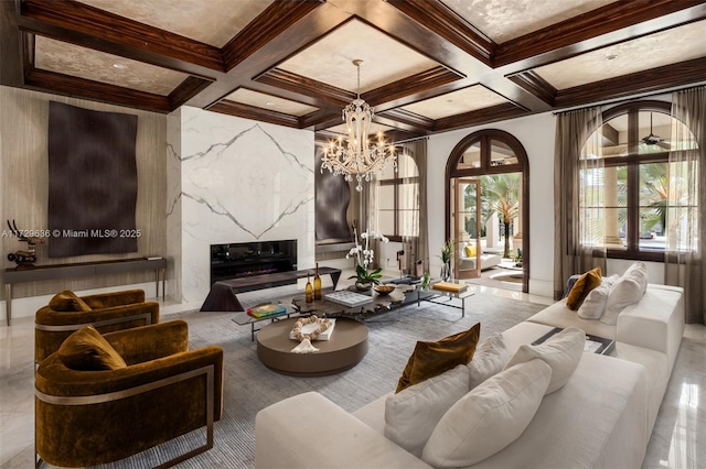 living room with beam ceiling, a fireplace, a chandelier, crown molding, and coffered ceiling