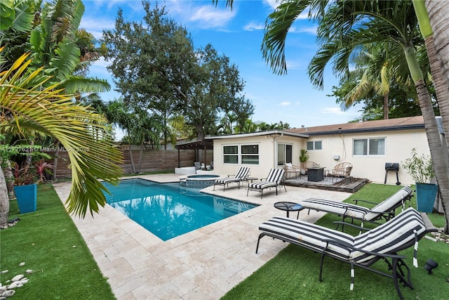 view of pool featuring a lawn, a patio, and an in ground hot tub