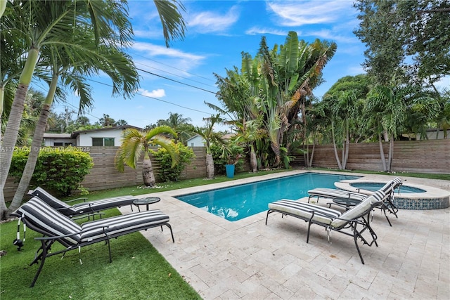 view of swimming pool featuring an in ground hot tub and a patio