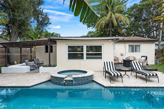 rear view of house featuring a pool with hot tub and a patio