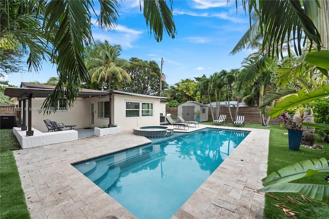 view of swimming pool with an in ground hot tub, a patio area, central air condition unit, and a shed