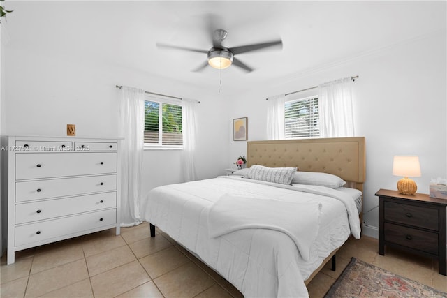 tiled bedroom featuring multiple windows and ceiling fan