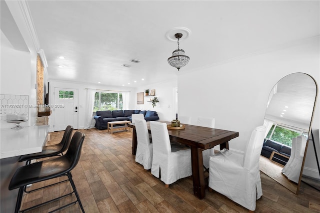 dining room with dark wood-type flooring and ornamental molding