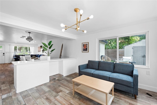 living room with an inviting chandelier, hardwood / wood-style floors, and crown molding