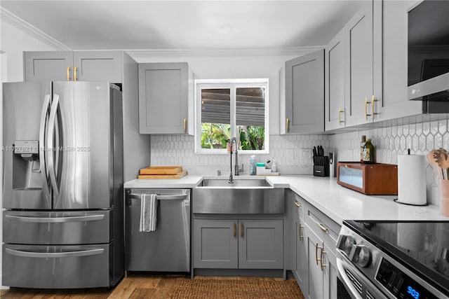 kitchen featuring gray cabinetry, sink, decorative backsplash, and stainless steel appliances