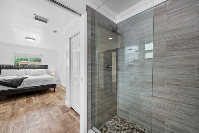 bathroom with ornamental molding and tiled shower