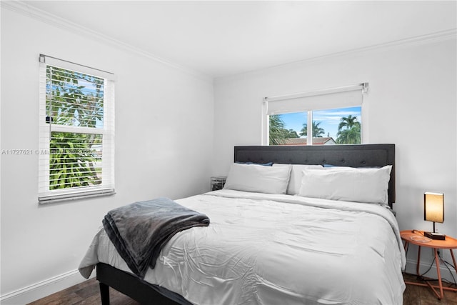 bedroom with multiple windows, ornamental molding, and dark hardwood / wood-style flooring