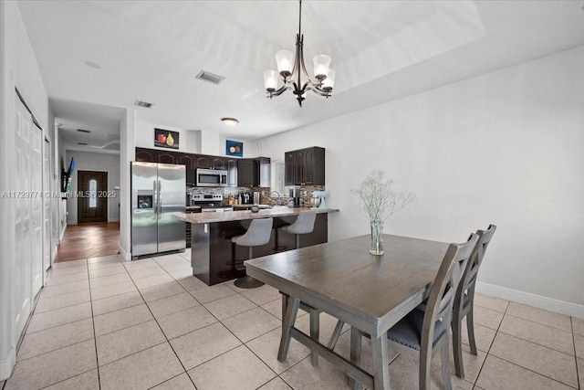 dining area featuring a notable chandelier and light tile patterned floors