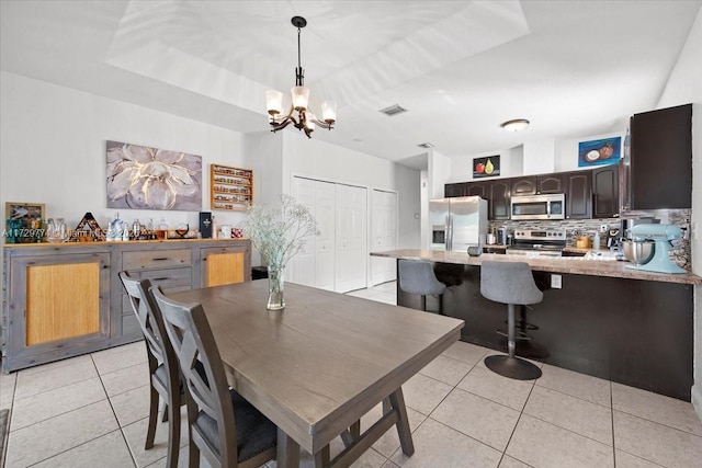 dining space featuring a chandelier and light tile patterned floors