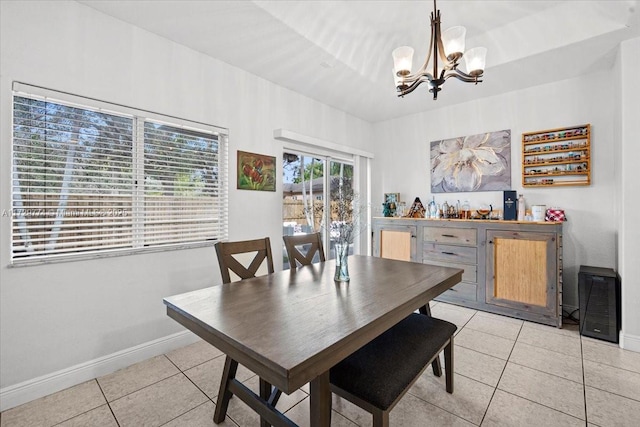 dining space featuring light tile patterned floors and an inviting chandelier