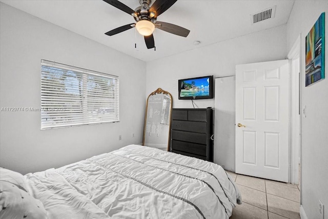 tiled bedroom featuring ceiling fan