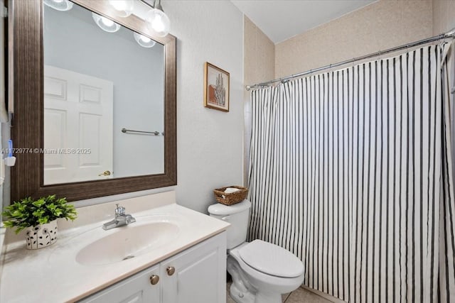 bathroom with toilet, a shower with shower curtain, and vanity