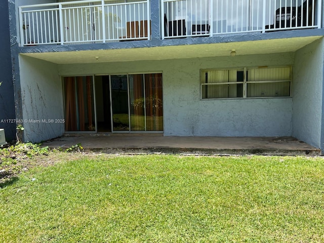 rear view of property featuring a balcony and a patio area