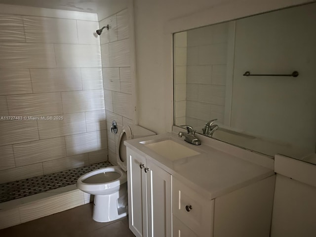 bathroom with vanity, toilet, tiled shower, and tile patterned flooring