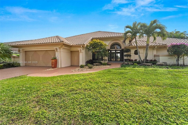 mediterranean / spanish home featuring a garage, french doors, and a front lawn