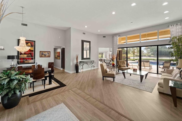 living room with a towering ceiling and light wood-type flooring