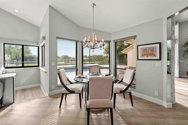 dining space with lofted ceiling, light hardwood / wood-style flooring, and a notable chandelier