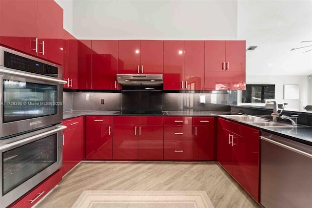 kitchen featuring light hardwood / wood-style floors, sink, backsplash, and stainless steel appliances