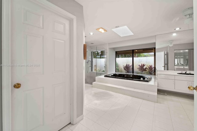 bathroom featuring vanity, a skylight, shower with separate bathtub, and tile patterned flooring