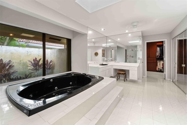 bathroom featuring shower with separate bathtub, vanity, and tile patterned flooring