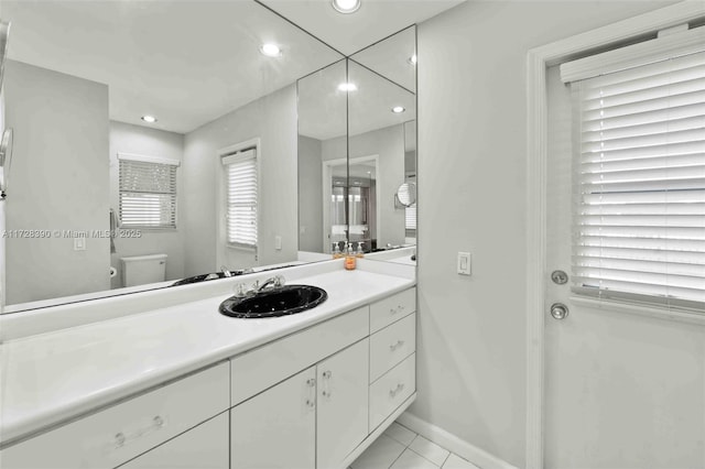 bathroom with toilet, tile patterned floors, and vanity