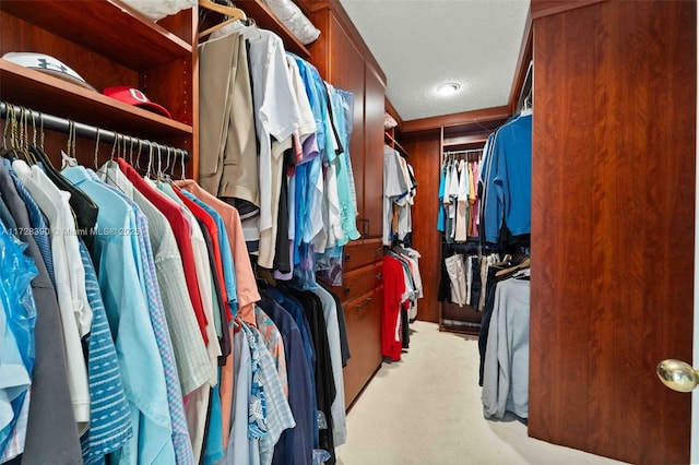 walk in closet featuring light colored carpet