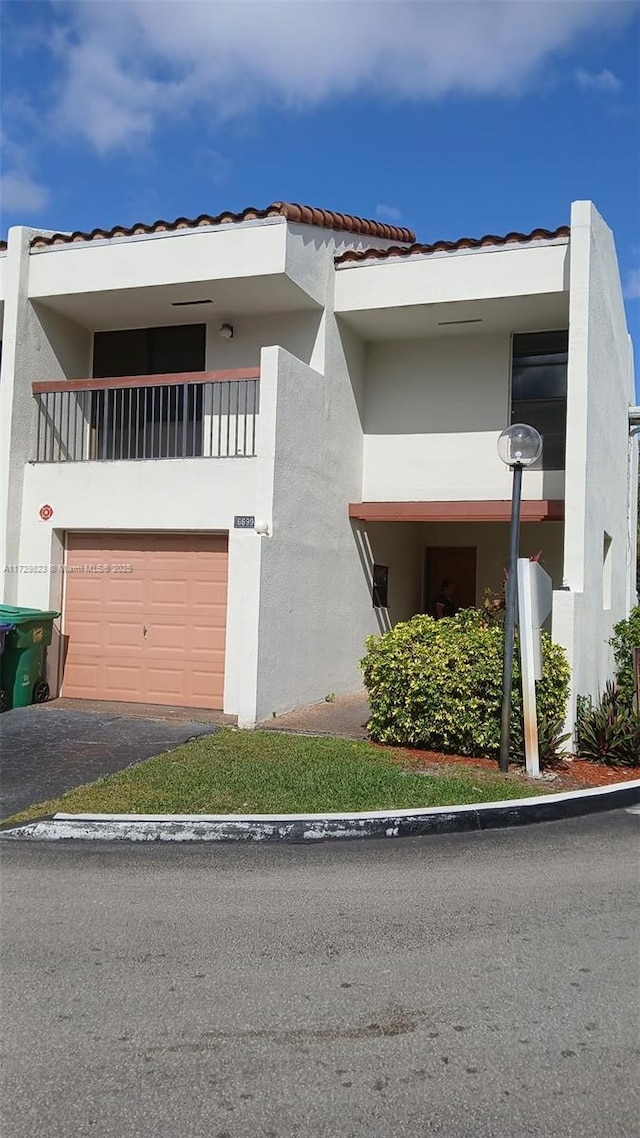 view of front of house featuring a garage and a balcony