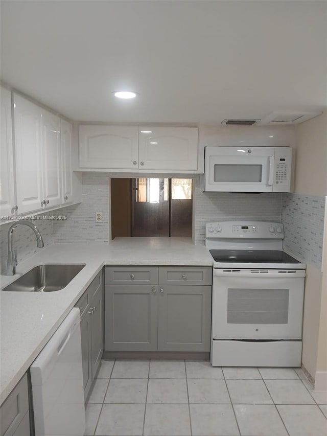 kitchen with white appliances, sink, decorative backsplash, and white cabinets