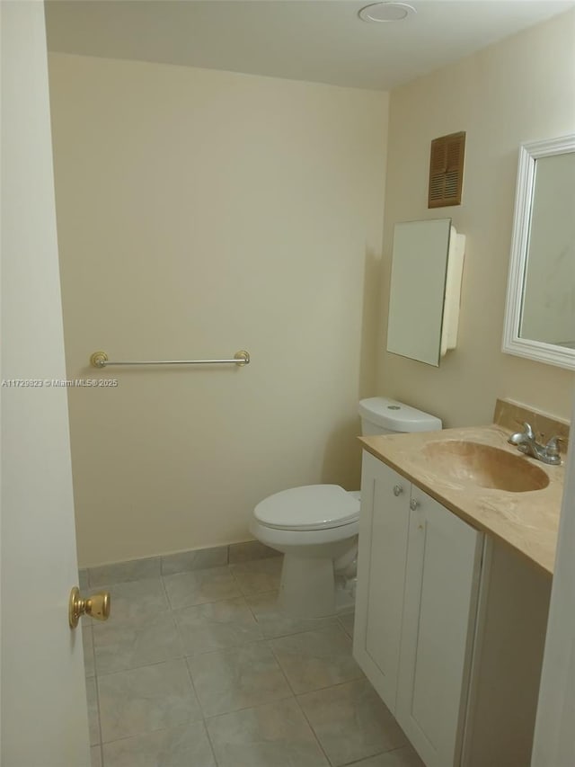 bathroom with tile patterned flooring, vanity, and toilet