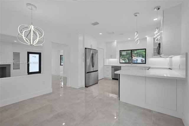 kitchen with stainless steel appliances, kitchen peninsula, white cabinets, and decorative light fixtures