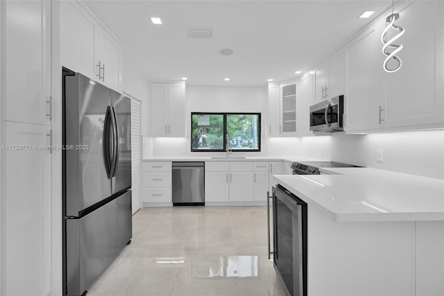 kitchen with wine cooler, sink, white cabinetry, kitchen peninsula, and stainless steel appliances