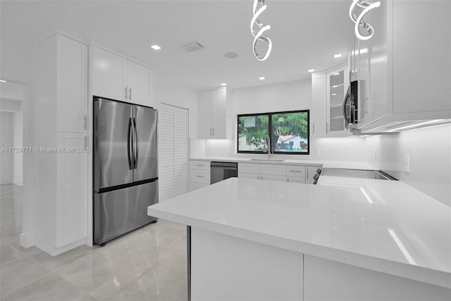 kitchen with stainless steel refrigerator, kitchen peninsula, dishwasher, and white cabinets