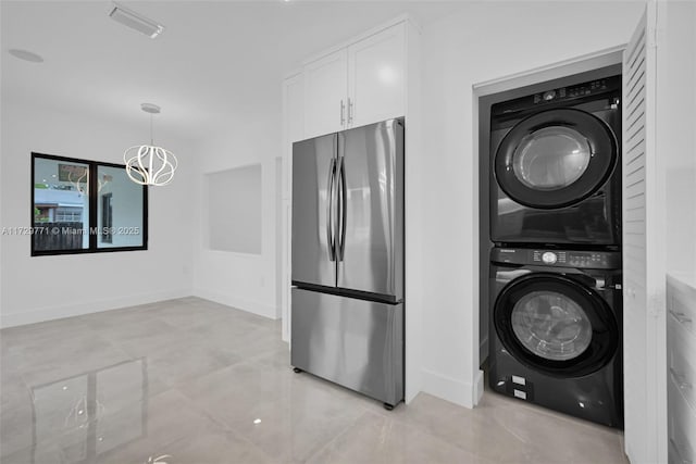 laundry room with stacked washer / dryer and a chandelier