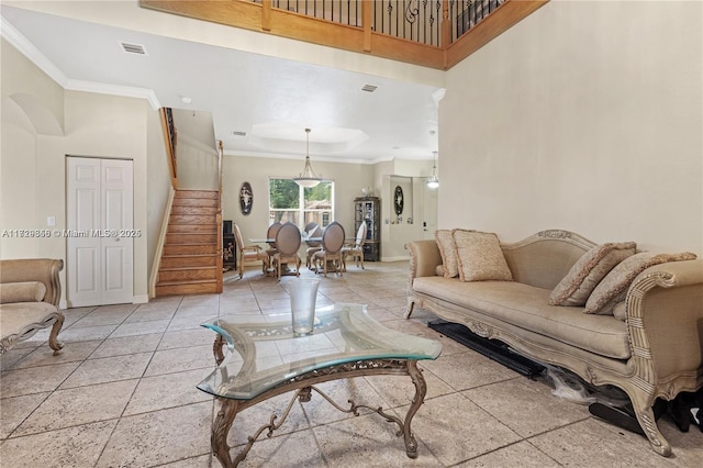 living room with a high ceiling, crown molding, and a tray ceiling