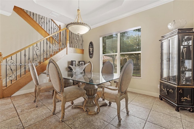 dining room featuring ornamental molding and a raised ceiling