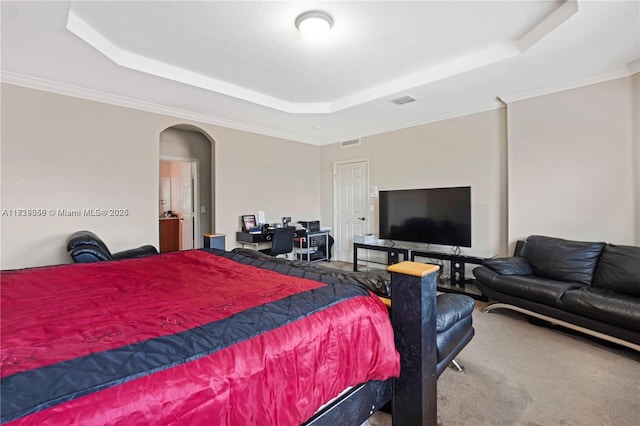 bedroom with crown molding, carpet flooring, and a raised ceiling