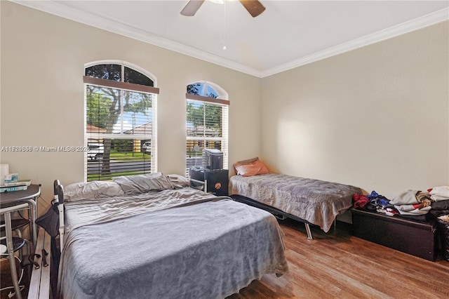 bedroom featuring hardwood / wood-style floors, ornamental molding, and ceiling fan