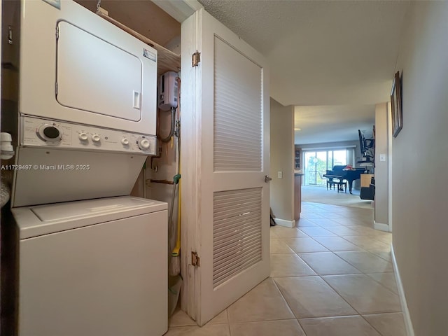 9400 N Hollybrook Lake Dr Unit 303, Pembroke Pines, FL 33025 - laundry area featuring baseboards, stacked washer / dryer, and light tile patterned flooring
