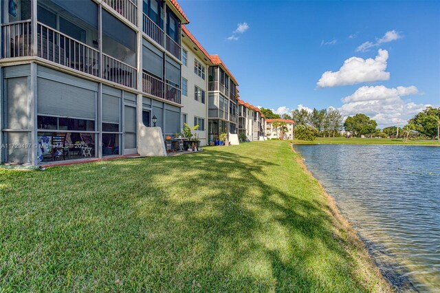 surrounding community with a water view and a yard