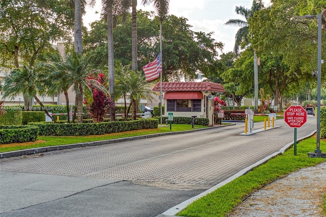 9400 N Hollybrook Lake Dr Unit 303, Pembroke Pines, FL 33025 - view of street with a gated entry, curbs, and traffic signs