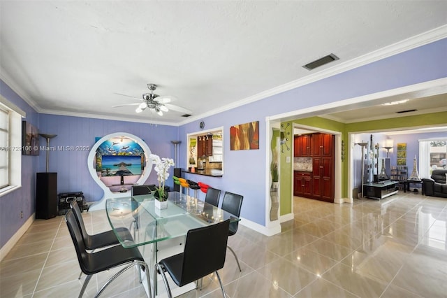 dining room with crown molding, light tile patterned floors, and a wealth of natural light