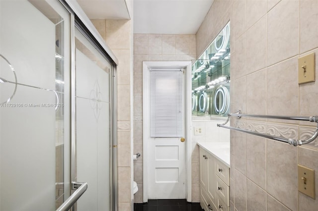 bathroom with vanity, walk in shower, and tile walls