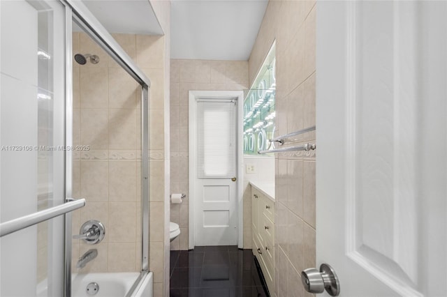 2070 NW 84th Ter, Pembroke Pines, FL 33024 - bathroom with toilet, bath / shower combo with glass door, tile walls, vanity, and tile patterned floors